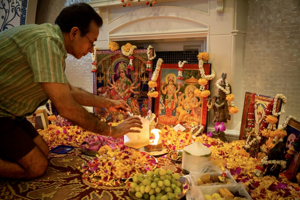 Image of man in lap of light bulbs on Diwali celebration day