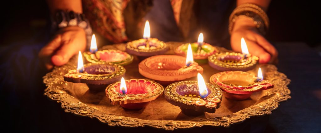 Woman with lamps of lights in celebration of Diwali. 