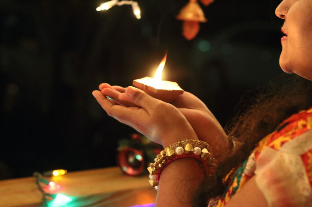 Image of a woman with a lamp of light, celebrating Diwali.