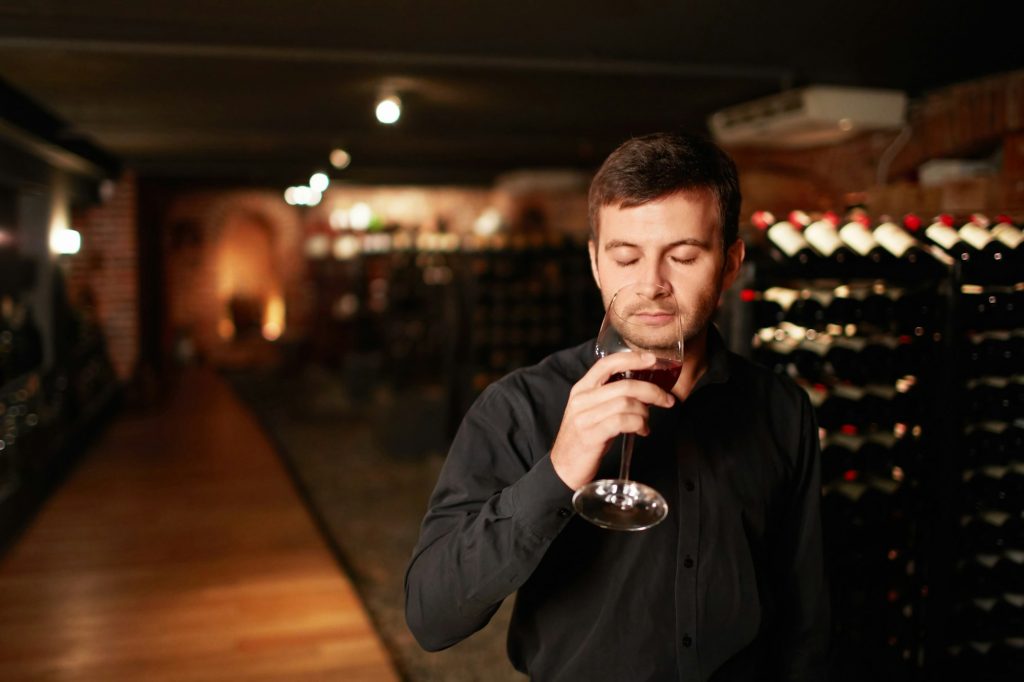 Image of a man enjoying a glass of wine.