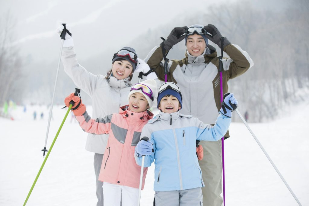 Image of happy family skiing in the snow