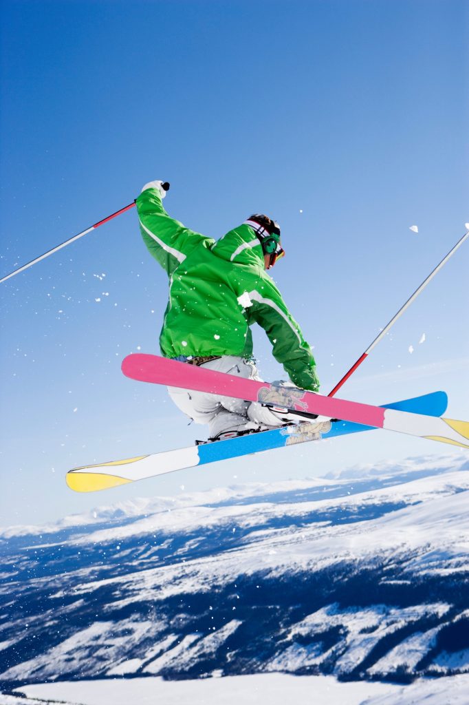 Man grabbing skis mid-air.